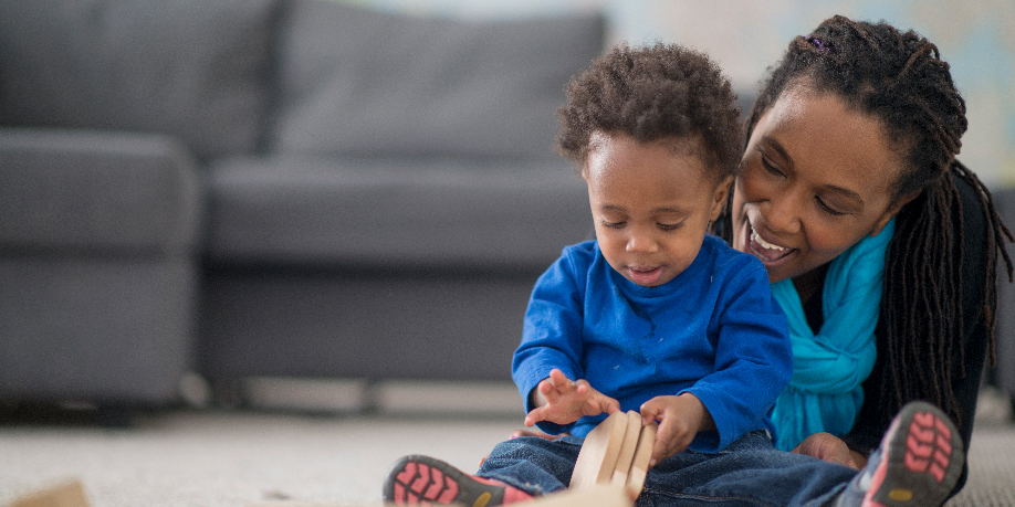 A young child and his mother play with building blocks.